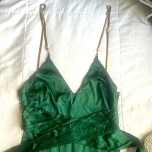 Evergreen jumpsuit with gold straps ; necklace like material .